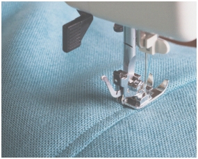 伝統的なアパレルを感じさせる、生地とミシンのクローズアップ